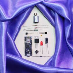 A purpe satin sheet encircles disassembled electronic parts.
