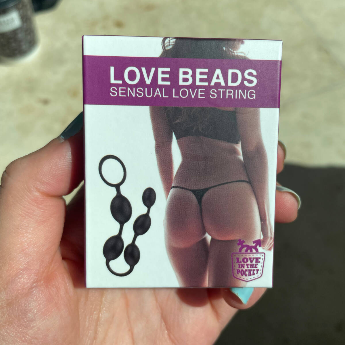 Image of women holding packet of sex toy 'Love Beads Sensual love string'