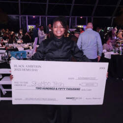Glenise holding a check for $250,000.